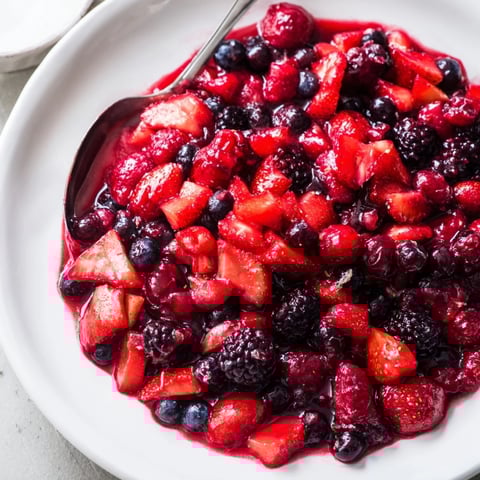 Bunte Warmbeerenkompott in einer Schüssel, perfekt für Pancakes oder Joghurt.  